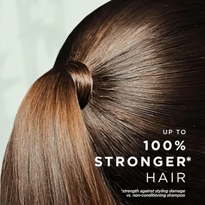 Highlights the product's ability to make hair up to 100% stronger against styling damage compared to non-conditioning shampoo.