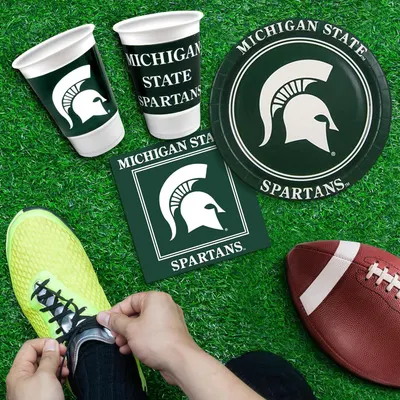 Shows all the Michigan State Spartans branded items included in the party pack, such as cups, plates, and napkins, to help shoppers understand what they receive with their purchase.