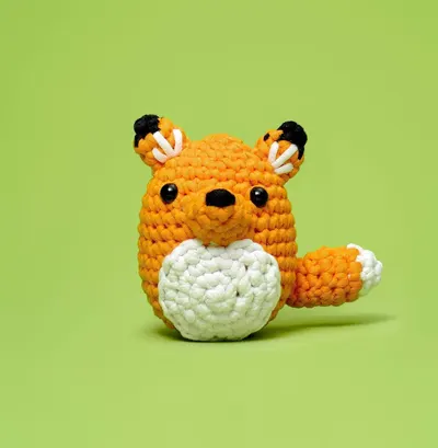 Shows the crocheted toy product in a clean, simple setting to help shoppers visualize the item's appearance and craftsmanship.