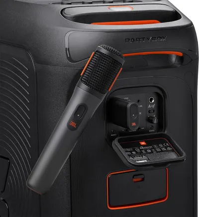 Shows the back panel design and storage features of the speaker system, highlighting where the microphone is stored and the various control ports and compartments available.