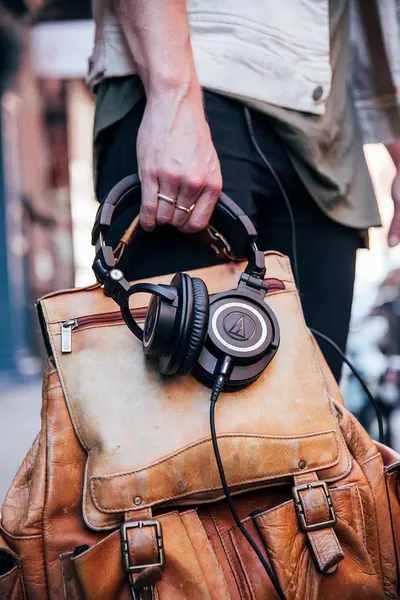 Shows the headphones in a real-world travel context to help shoppers visualize how the product fits into their daily lifestyle and portability needs.