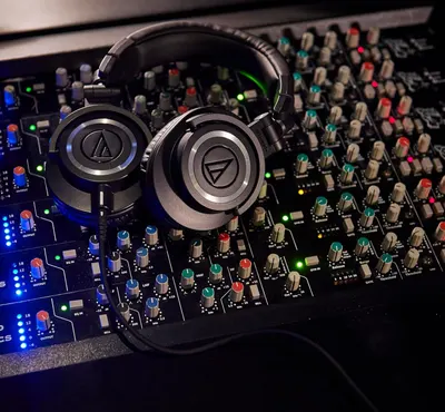 Shows the headphones in a real-world professional audio mixing context to help shoppers visualize the product being used with studio equipment and understand its intended application.