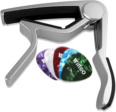 Shows the customer everything included in the purchase: a guitar capo and multiple colorful guitar picks, helping them understand the complete value of the bundle.