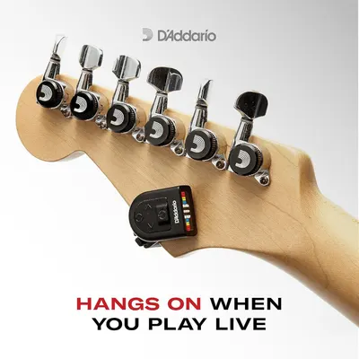 Communicates that the tuner remains securely mounted on the guitar headstock during live play, reassuring musicians they can tune without removing or losing the device.