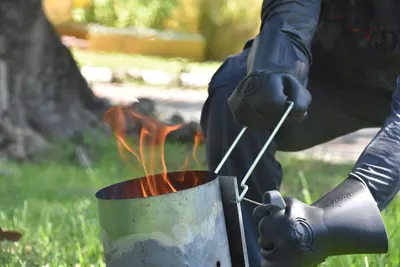Demonstrates the gloves ability to safely handle hot objects and protect hands from fire and extreme heat during outdoor cooking or camping activities.