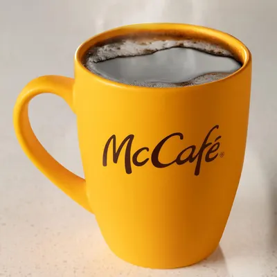 Emphasizes the McCafe brand through prominent logo placement on the mug to build brand recognition and trust with shoppers.