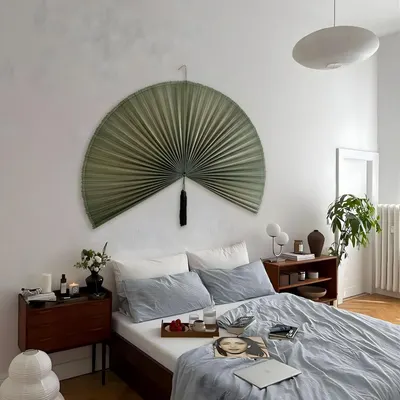 Shows the product displayed as wall decor in a real bedroom setting to help shoppers visualize how it looks in their own home.
