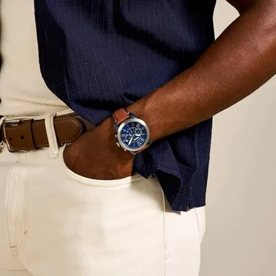 Demonstrates the product worn in a real-world setting to help shoppers visualize how the watch looks when styled with everyday clothing.