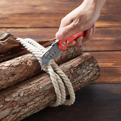 Demonstrates the product in a realistic outdoor setting, showing the knife being used to cut rope on wood, helping shoppers visualize practical applications.