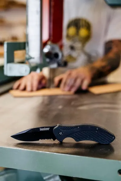 Shows the product in an authentic workshop or home environment to help shoppers visualize the knife as a practical everyday tool.