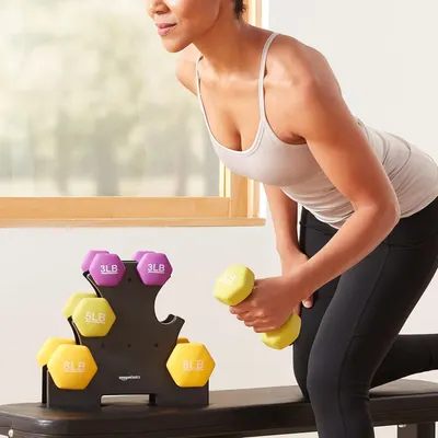 Demonstrates the product in a real-world home fitness setting to help shoppers visualize using the dumbbell set in their own space.