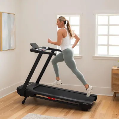 Demonstrates the product in a real-world home environment to help shoppers visualize the treadmill in their own space and see it in use.