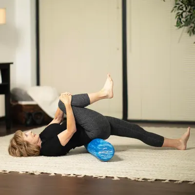 Demonstrates the product being used in a real-world home fitness setting to help shoppers visualize how the foam roller fits into their exercise routine.