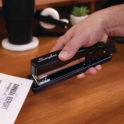 Demonstrates the product in a natural office setting to help shoppers visualize how the stapler fits into their everyday work environment.