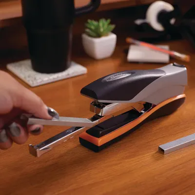 Demonstrates the product in a natural office environment to help shoppers visualize how the stapler fits into their everyday workspace.