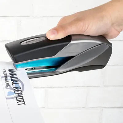 Shows the stapler being used in a real-world context to help shoppers visualize how the product functions and fits into everyday office tasks.