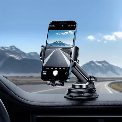 Demonstrates the product in a real-world driving scenario, showing how the phone mount securely holds a device on the dashboard for navigation or hands-free use during travel.