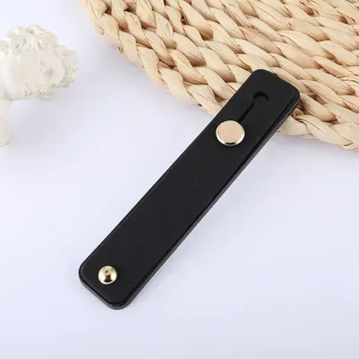 Provides a clean, catalog-style view of the product (black leather strap with gold snaps) to show its appearance and design without distractions.