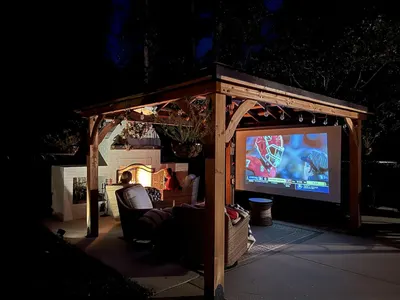 Demonstrates the product in a real-world backyard setting at night, showing how it creates an inviting outdoor living and entertainment area.