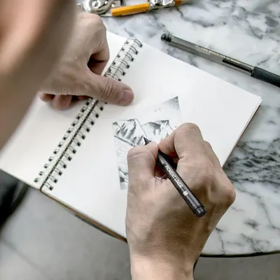 Demonstrates the product being used in a real-world creative setting to help shoppers visualize themselves using the drawing/sketching tool.