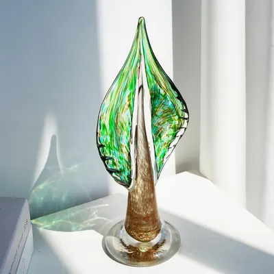 Shows the product in a real-world home setting to help shoppers visualize how the decorative glass art piece would look displayed in their own space.