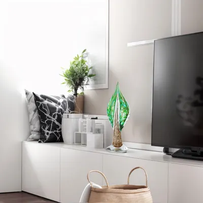 Showcases the product (decorative glass leaf sculpture) in a real-world home setting to help shoppers visualize how it fits into modern interior design.