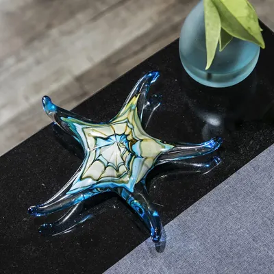 Showcases the product in a real-world home setting to help shoppers visualize how the decorative glass piece would look styled in their own space.