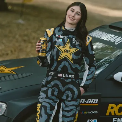 Showcases the product in an authentic racing lifestyle setting to create aspirational appeal and demonstrate real-world use by a professional athlete.