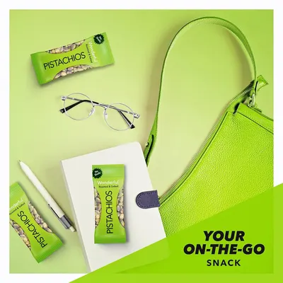 Communicates that the pistachios are a convenient, portable snack perfect for busy, on-the-go lifestyles by showing them alongside everyday carry items.