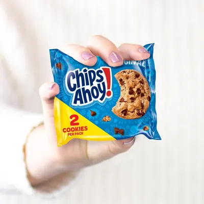 Shows authentic, relatable customer usage of the product in a real-world setting to build trust and demonstrate portability. Highlights the convenient portion-controlled packaging with 2 cookies per…