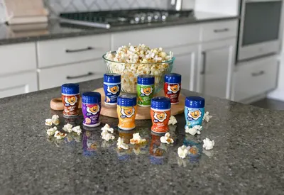 Displays the brand's full range of popcorn seasoning flavors to help shoppers understand the variety available and choose their preferred option.