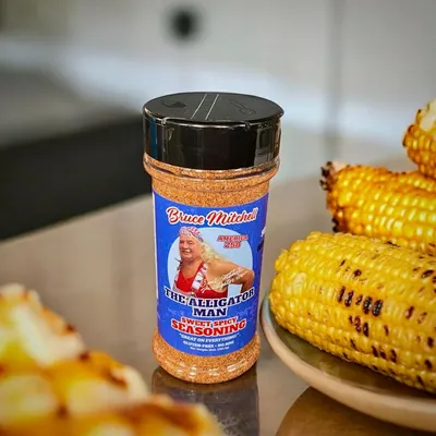 Shows the product in an authentic home setting with prepared food to help shoppers visualize how they would use the seasoning in their own cooking.