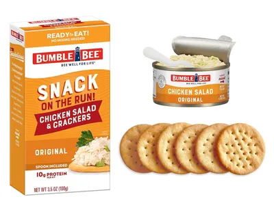 Shows the complete contents of the snack kit—the box, chicken salad can with spoon, and crackers—to help shoppers understand exactly what they receive when purchasing this ready-to-eat meal.