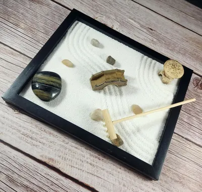 Shows all the components included with the product—sand, stones, rake, and decorative elements—to help shoppers understand the complete kit they will receive.