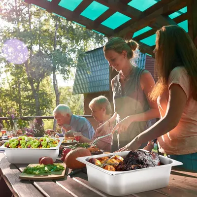 Showcases the product in a real-world outdoor family gathering context to help shoppers visualize using it for entertaining and meal preparation in their own lives.