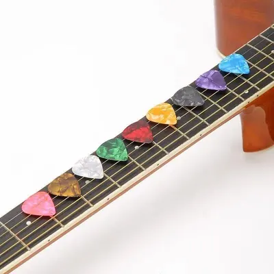 Shows the variety of colorful guitar picks included with the product, demonstrating the value and options the customer receives. Displays the range of color options available in the product line,…