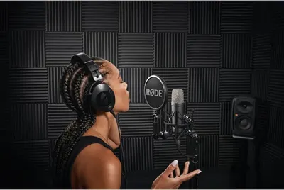 Demonstrates the product in a real-world professional recording studio setting to help shoppers visualize the microphone's use in high-quality audio production contexts.
