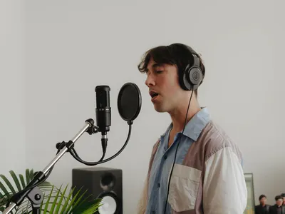 Demonstrates the product being used in a real-world recording or podcasting environment to help shoppers visualize themselves using the microphone and headphones setup.