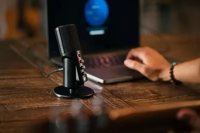 Demonstrates the product in a real-world recording or podcasting environment to help shoppers visualize how the microphone fits into their workspace and daily use.