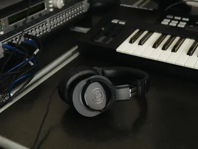 Demonstrates the headphones in a real-world professional music production setting to help shoppers visualize the product in use with studio equipment.