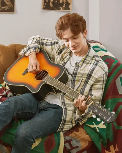 Demonstrates the guitar being used in a relaxed, real-world home setting to help shoppers visualize the product in their own lifestyle and connect emotionally with the product.