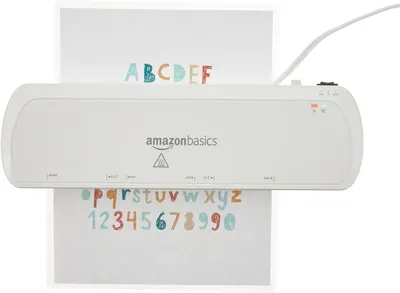 Provides a clean, catalog-style product image showing the AmazonBasics laminator in use with a sample document, allowing shoppers to see the product clearly without distractions.