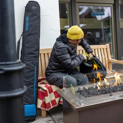 Demonstrates the product in a real-world winter/ski resort environment to help shoppers visualize using it during their outdoor adventures.