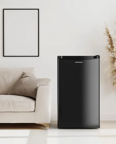 Shows the mini fridge in a real-world living room setting to help shoppers visualize how the compact appliance fits naturally into their home decor and lifestyle.