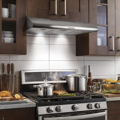 Demonstrates the product (range hood) in a real-world kitchen setting to help shoppers visualize how it looks and fits in their own home.