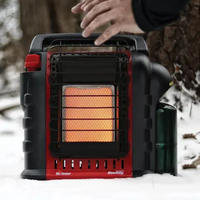 Demonstrates the portable heater being used in a real-world outdoor winter setting, showing its practical application in cold weather conditions.