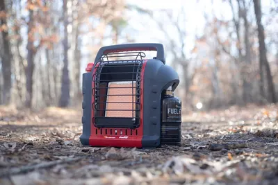 Demonstrates the product in a real-world outdoor setting to show shoppers where and how the portable heater can be used in nature or camping scenarios.