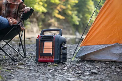 Demonstrates the portable heater in a real-world camping environment to help shoppers visualize using the product outdoors for warmth and comfort.