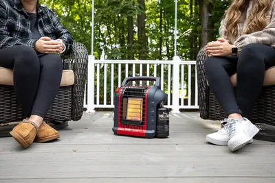 Demonstrates the product in a real-world outdoor setting to show shoppers how the portable heater can be used on a patio or deck for comfort during cooler weather.