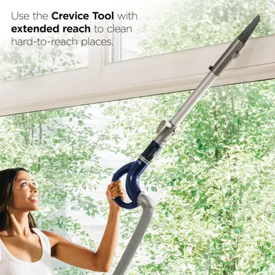 Demonstrates how to use the crevice tool attachment with extended reach to clean hard-to-reach places like ceiling corners and high surfaces. Highlights the extended reach capability of the crevice…